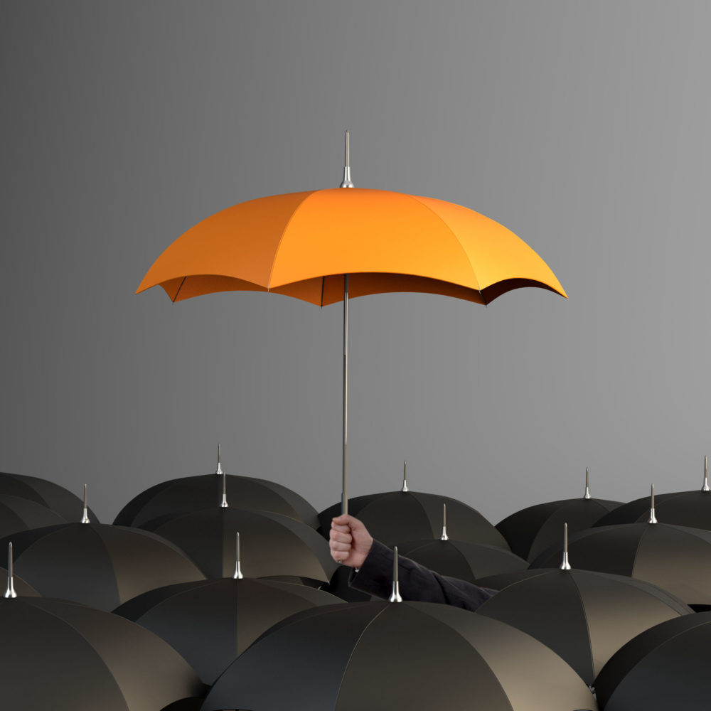 Orange Colored Umbrella Between The Black Umbrellas